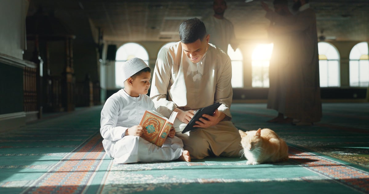 Teacher helping a young student read the Quran
